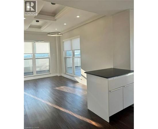 A spacious kitchen with white cabinets and a black countertop.