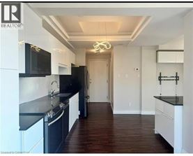 A modern kitchen with black countertops and white cabinets.