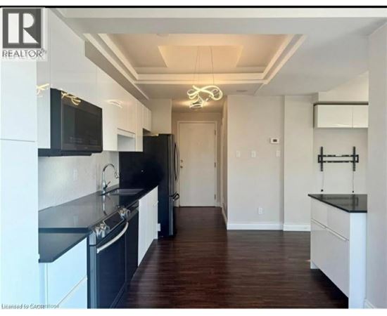 A modern kitchen with black countertops and white cabinets.