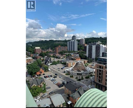 A cityscape with a large building in the center and a parking lot in the foreground.