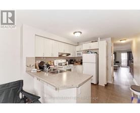 A kitchen with a sink, refrigerator, and cabinets.