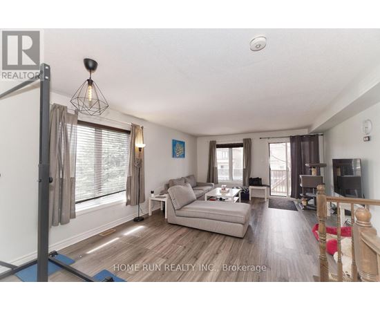 A living room with a grey couch and a wooden floor.