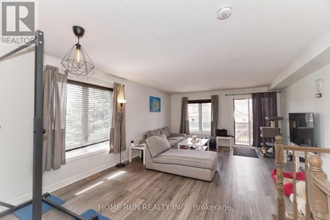 A living room with a grey couch and a wooden floor.