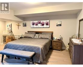 A bedroom with a bed, nightstand, and a bench.