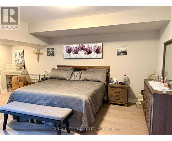 A bedroom with a bed, nightstand, and a bench.