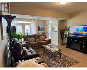 A living room with a brown couch, a coffee table, and a flat screen TV.