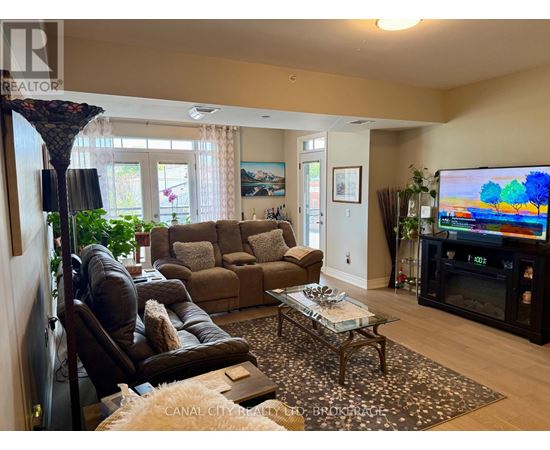 A living room with a brown couch, a coffee table, and a flat screen TV.