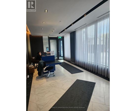 A room with a blue chair and a desk with a computer on it.
