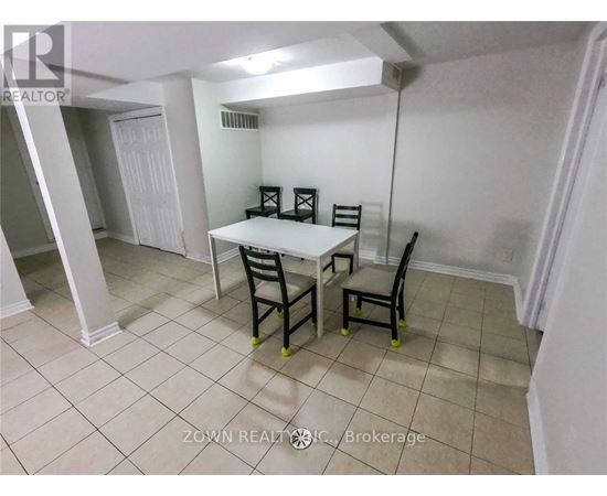 A dining room with a table and chairs.