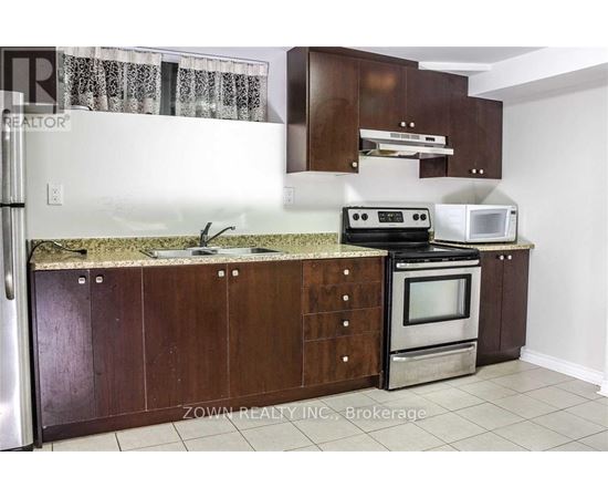 A kitchen with brown cabinets and a granite countertop.