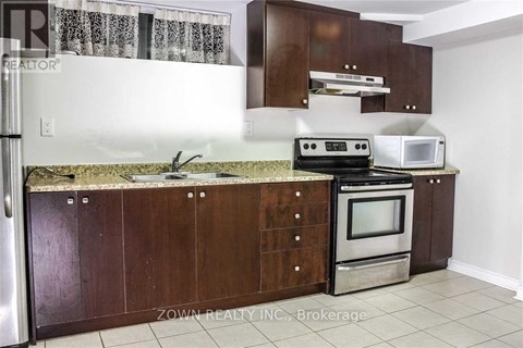 A kitchen with brown cabinets and a granite countertop.