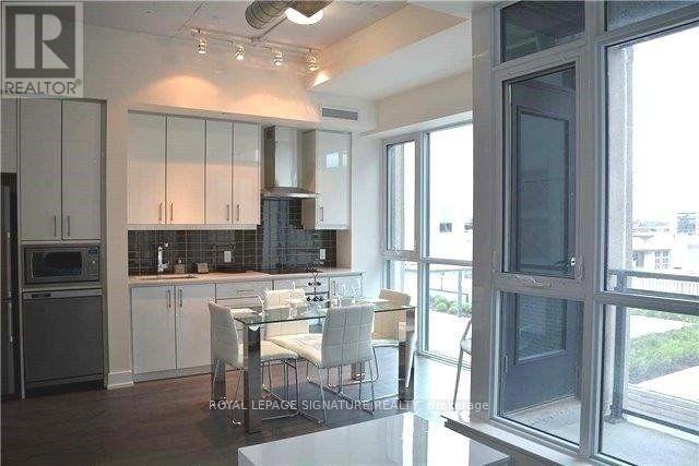 A kitchen with white cabinets and a dining table.