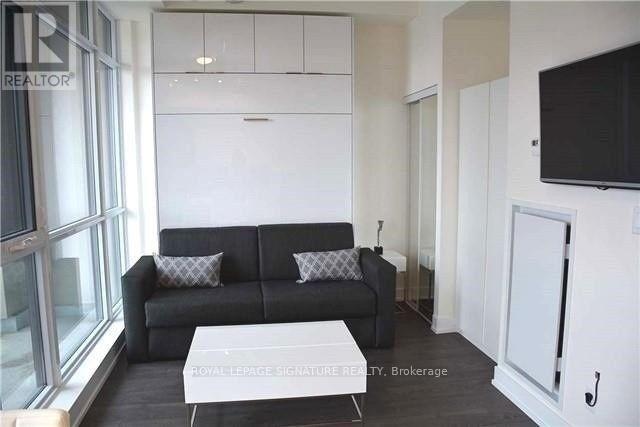 A living room with a black couch and a white coffee table.