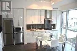 A kitchen with white cabinets and a glass table.