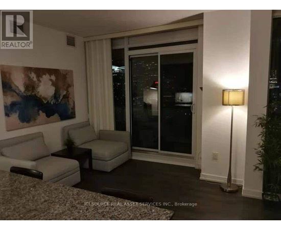 A living room with a couch, chair, and lamp.