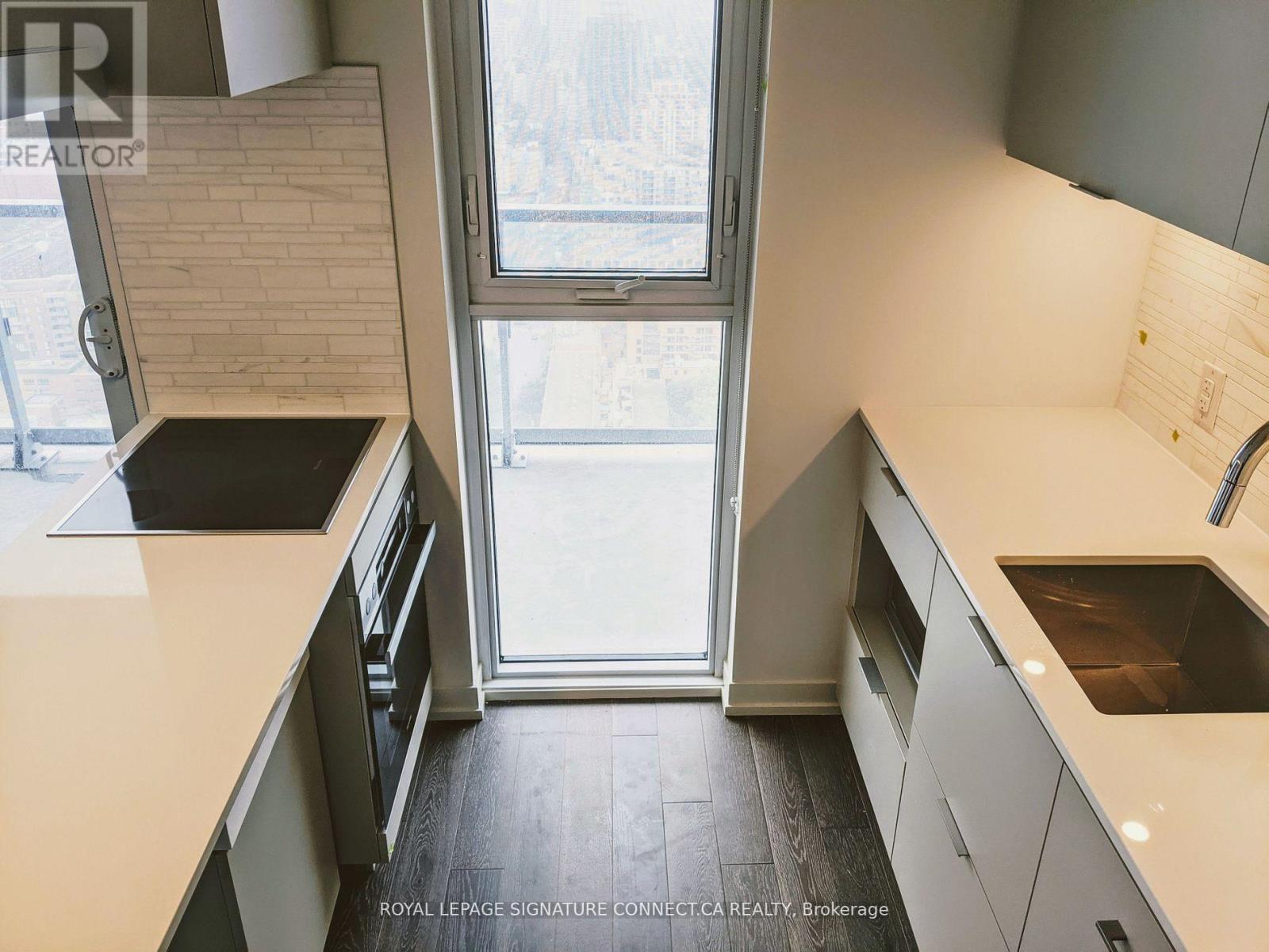 A kitchen with a window seat and a sink.
