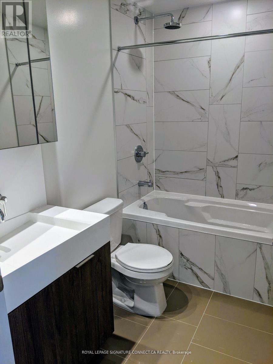 A white toilet sits in a marble bathroom.