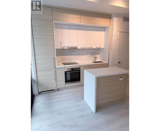 A modern kitchen with a white island and wooden cabinets.