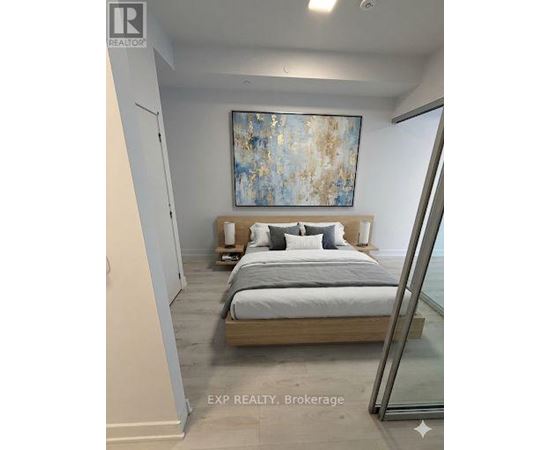 A bedroom with a bed, nightstands, and a painting on the wall.