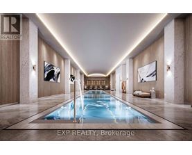 A long, narrow indoor swimming pool with a light blue color is the centerpiece of a luxurious room with marble floors and walls.