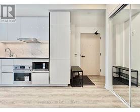 A modern kitchen with white cabinets and a black countertop.