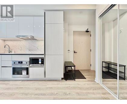 A modern kitchen with white cabinets and a black countertop.