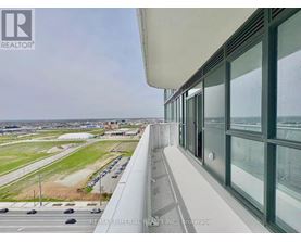 A view from a high-rise building looking out over a parking lot and a distant cityscape.