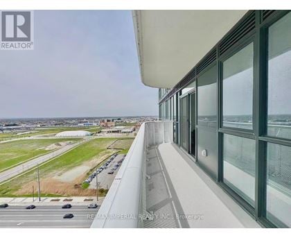 A view from a high-rise building looking out over a parking lot and a distant cityscape.