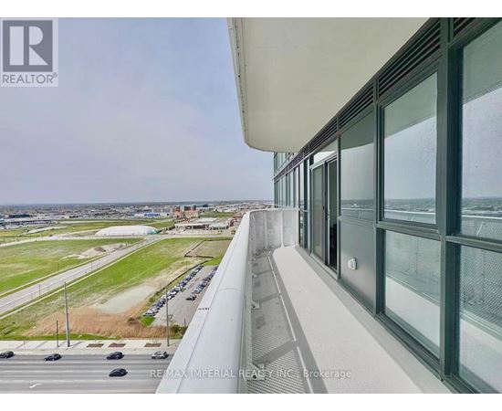 A view from a high-rise building looking out over a parking lot and a distant cityscape.