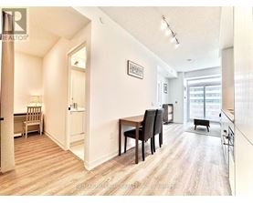 A well-lit apartment with a dining area and a kitchen in the background.