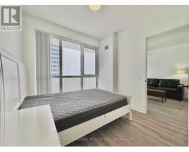 A bedroom with a large bed and a couch in the corner.