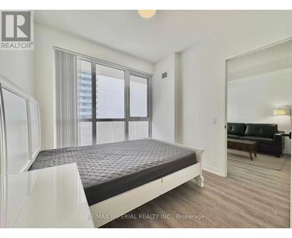 A bedroom with a large bed and a couch in the corner.