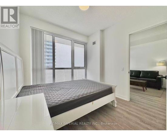 A bedroom with a large bed and a couch in the corner.