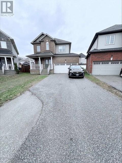 A black car is parked on a driveway in front of a house.