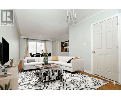 A living room with a white couch, a coffee table, and a chandelier.