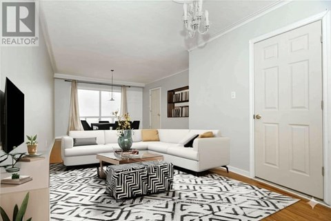 A living room with a white couch, a coffee table, and a chandelier.