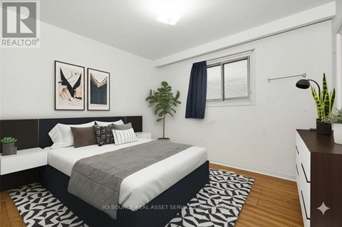 A bedroom with a bed, nightstand, and a plant.