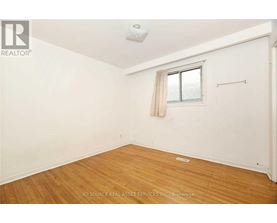 A room with a window and wooden flooring.
