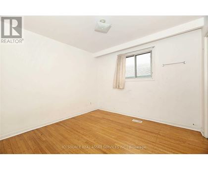 A room with a window and wooden flooring.