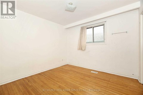 A room with a window and wooden flooring.