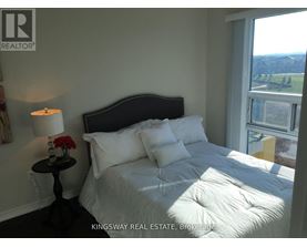 A bedroom with a large bed and a view of the outside.