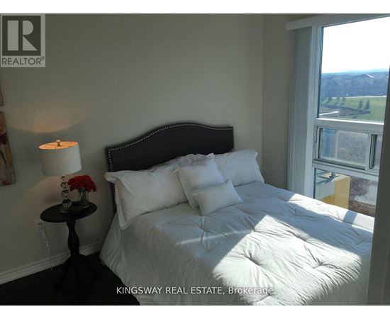 A bedroom with a large bed and a view of the outside.