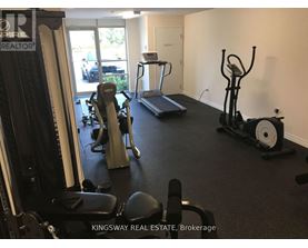 A gym with a variety of equipment including treadmills, weights, and exercise machines.