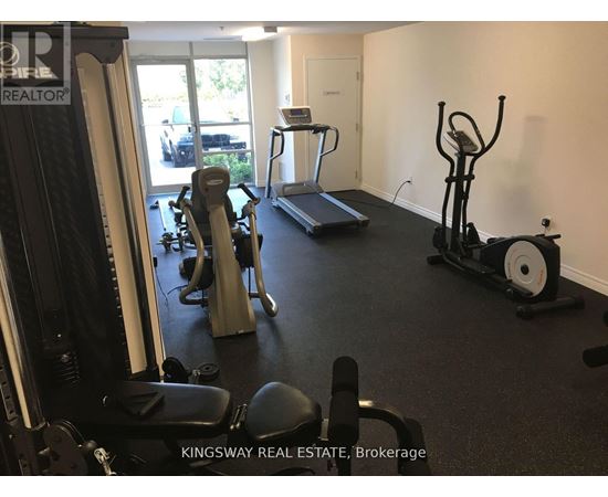 A gym with a variety of equipment including treadmills, weights, and exercise machines.