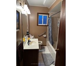 A bathroom with a brown door and a white sink.