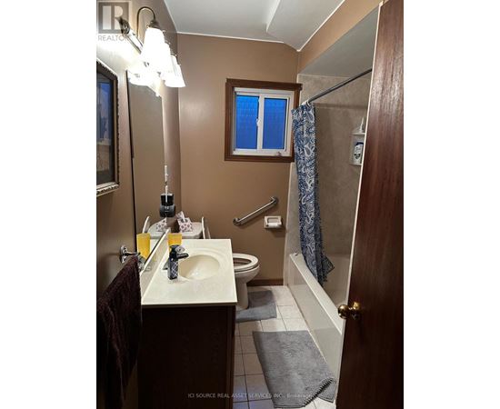 A bathroom with a brown door and a white sink.