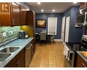 A kitchen with brown cabinets and a blue wall.