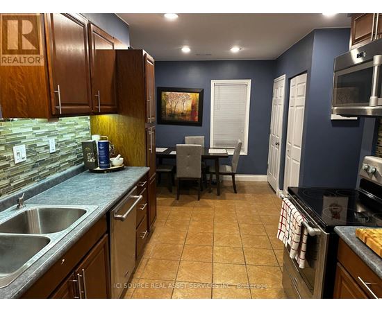 A kitchen with brown cabinets and a blue wall.