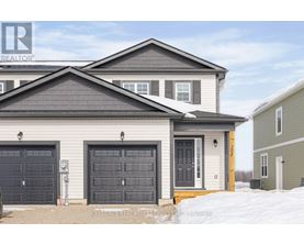 A house with a grey roof and a grey garage door.