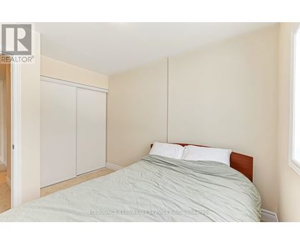 A bedroom with a bed, a wardrobe and a window.